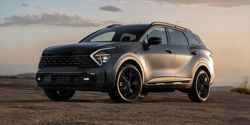 Silver Kia SUV parked on a scenic, rugged terrain.